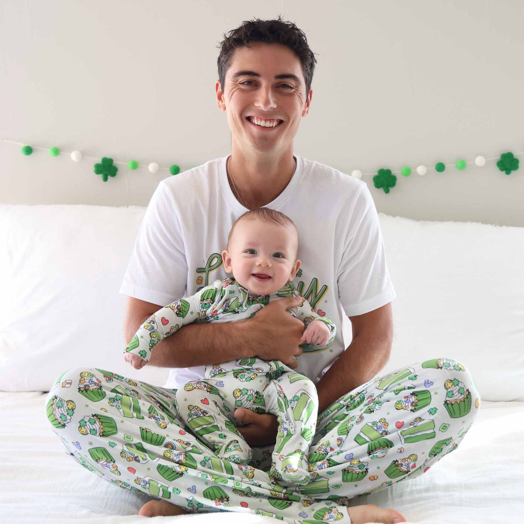 baby sitting on dad's lap in a st. patrick's day zipper footie with matching joggers