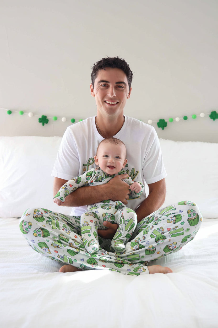dad holding baby wearing a st. patrick's day footie with matching adult pajama pants and t-shirt 