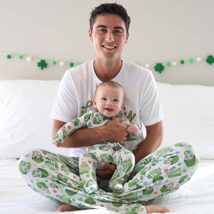 dad holding baby wearing a st. patrick's day footie with matching adult pajama pants and t-shirt 