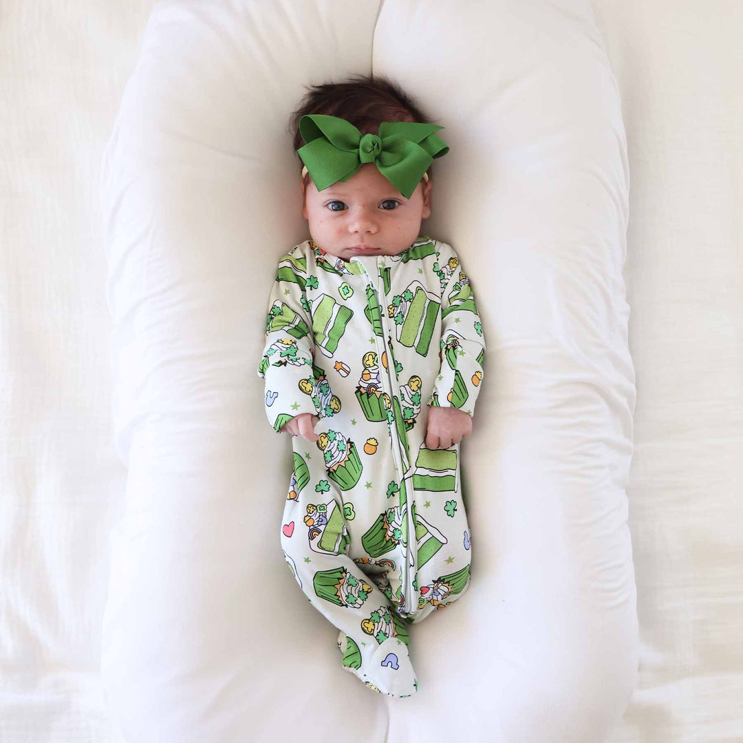 green cake bamboo baby footie pajama with a matching green ribbon bow headband 