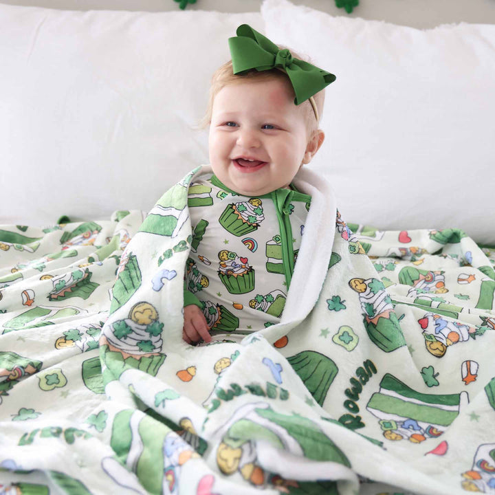 green cake, cupcake, lucky charm, rainbow and clover zip romper pajama with a matching personalized blanket and green ribbon bow headband 