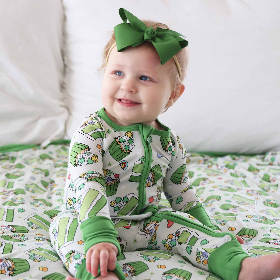baby girl wearing a green dessert convertible zip romper for st. patrick's day