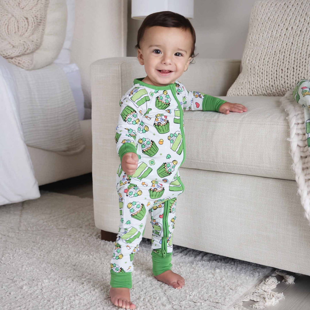 standing baby boy wearing a st. patrick's day dessert zip romper 