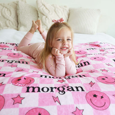 pink checkered blanket for kids with smiley faces