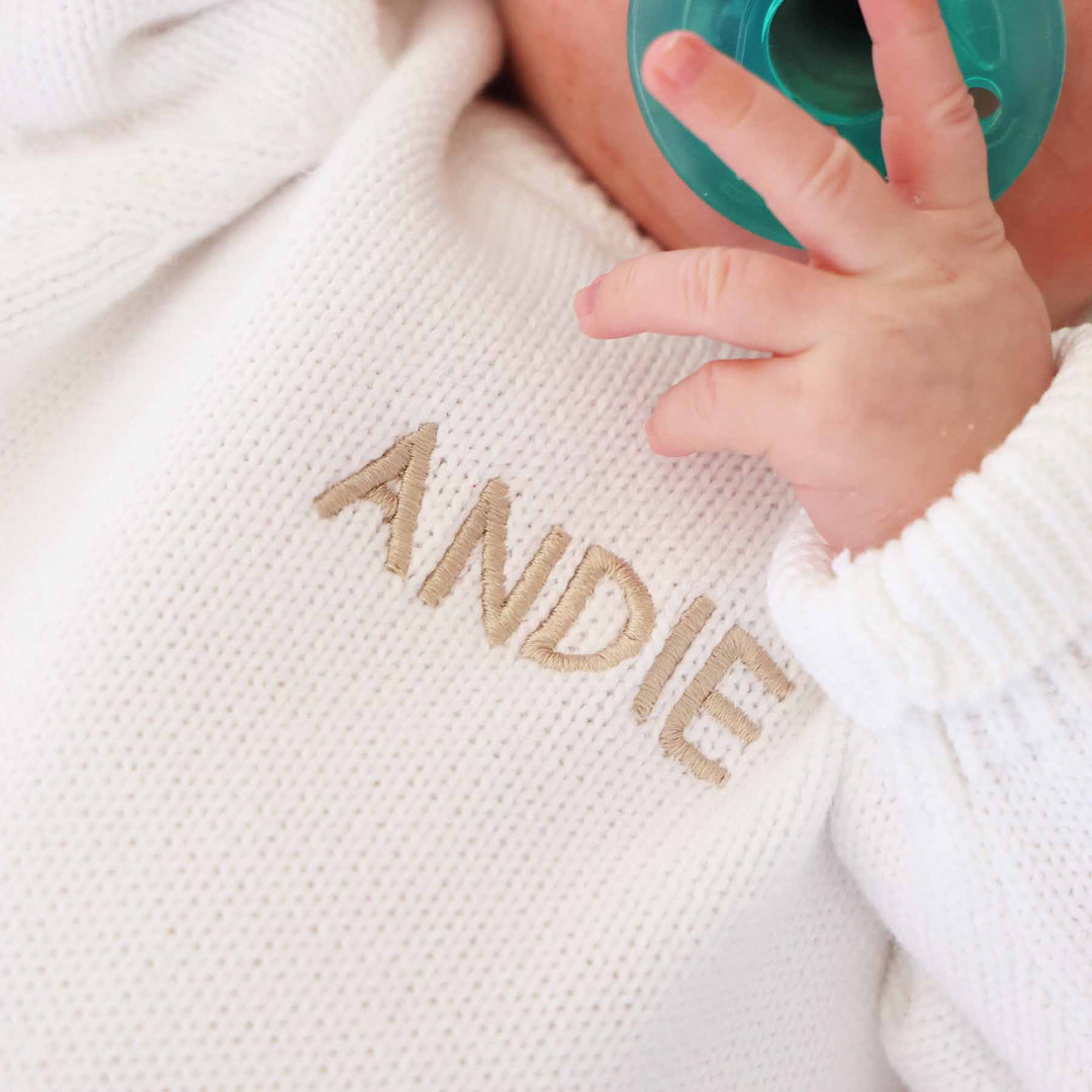 white personalized sweater romper for babies embroidered with name in tan thread