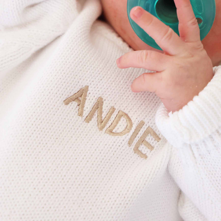 white personalized sweater romper for babies embroidered with name in tan thread