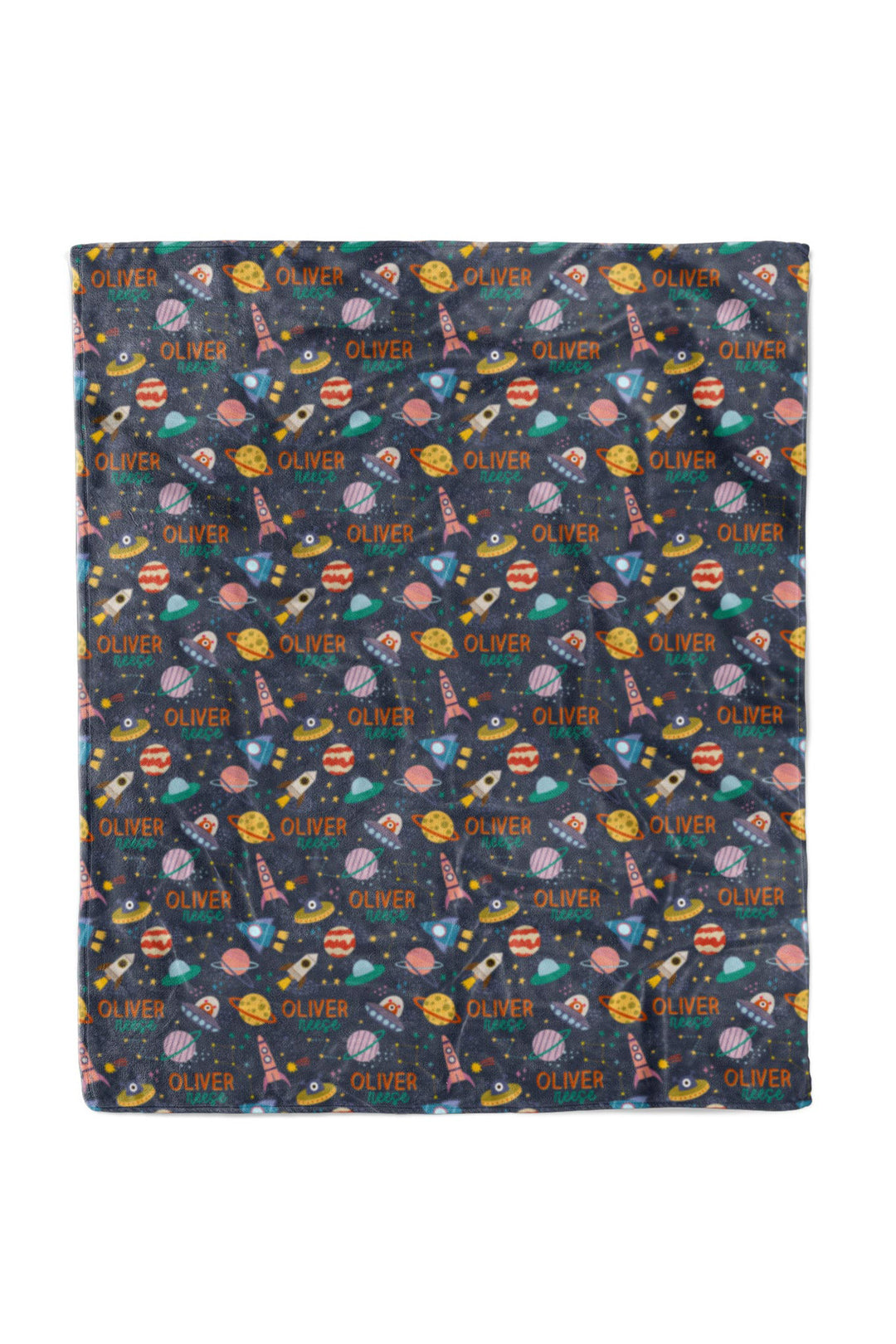 Flat lay of a fully unfolded personalized Caden Lane Star Explorer blanket in navy, showing the full repeating pattern of planets, rockets, and custom name