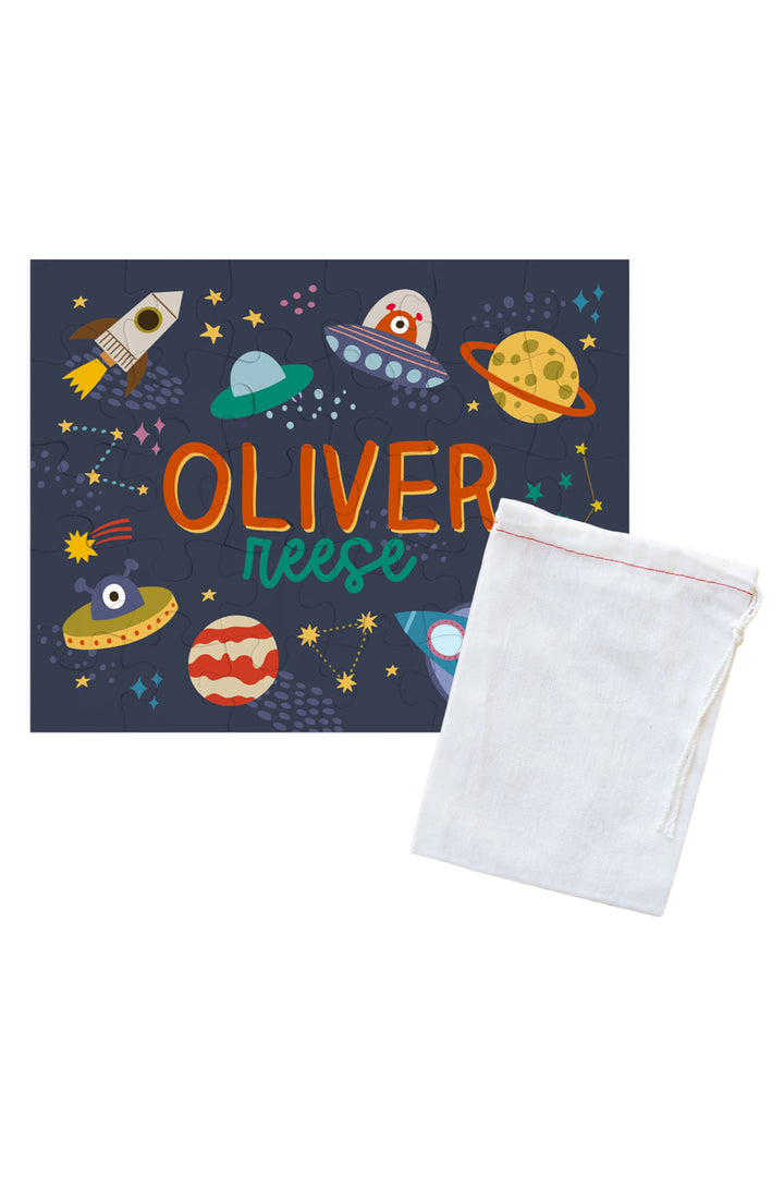 Personalized Caden Lane Star Explorer jigsaw puzzle in navy, showing rockets, planets, and custom name, paired with a white drawstring storage bag