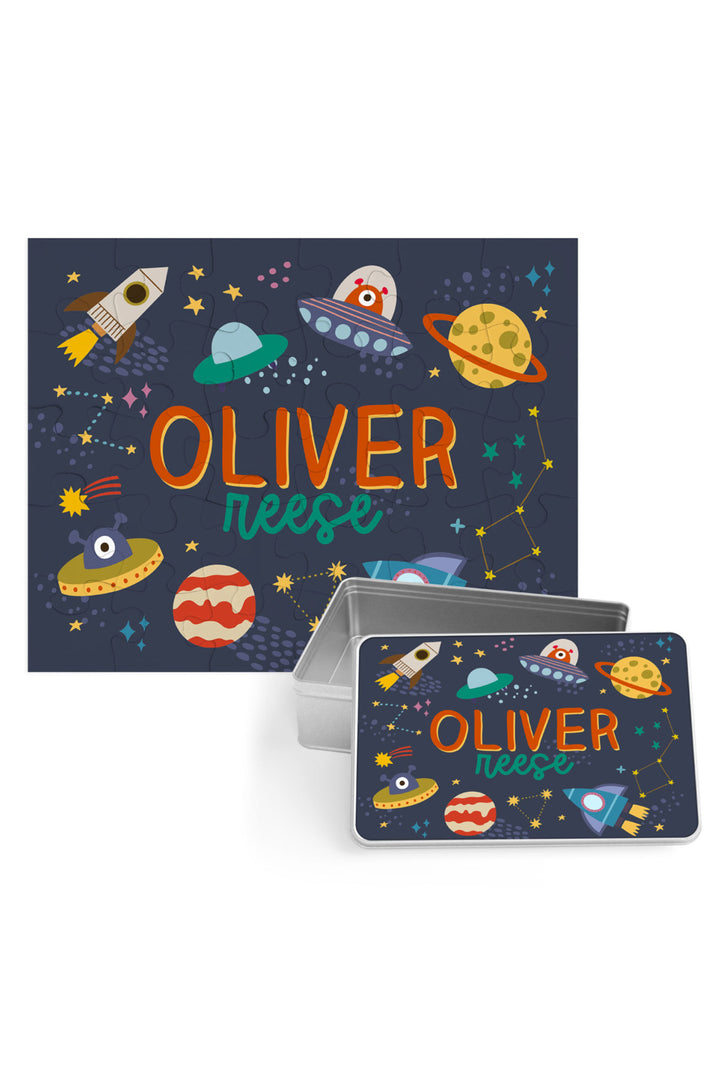 Personalized Caden Lane Star Explorer jigsaw puzzle in navy, showing rockets, planets, and custom name, paired with a matching silver storage tin