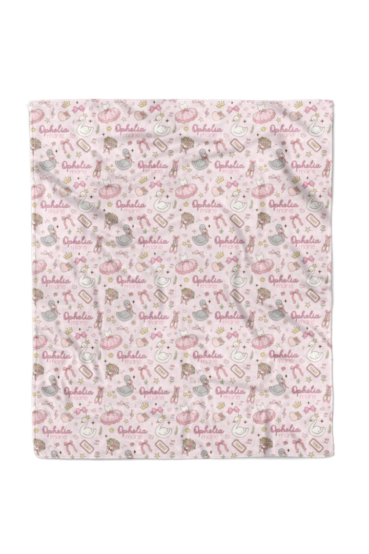 Flat lay of a fully unfolded personalized Caden Lane Swan Ballet blanket in pink, showing the full repeating pattern of swans, bows, and custom name