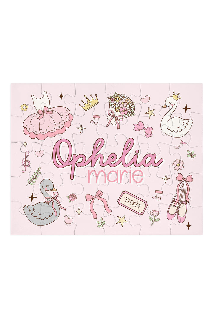 Flat lay of an assembled personalized Caden Lane Swan Ballet jigsaw puzzle in pink, showing ballet dress, swans, and custom name