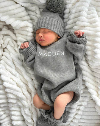 Baby wearing a Personalized Printed Knit Sweater Bubble in the color Smoke, with matching hat & booties