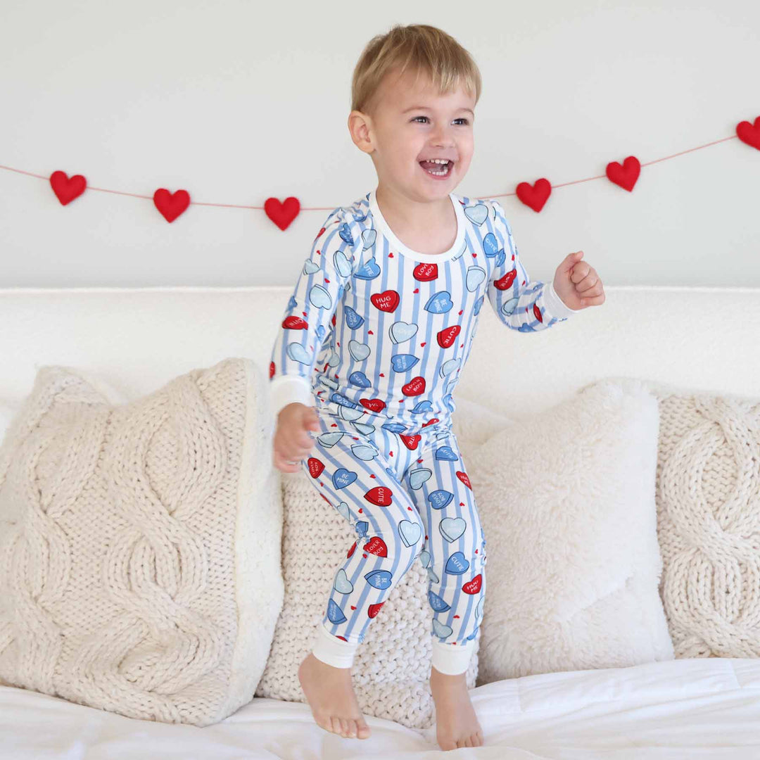 boy jumping on the bed in sweet like candy blue two piece pajama set for kids 