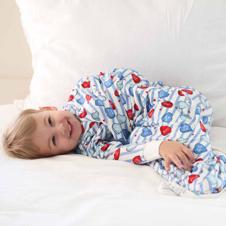boy laying on the bed wrapped in the sweet like candy blue double sided bamboo blanket for kids 