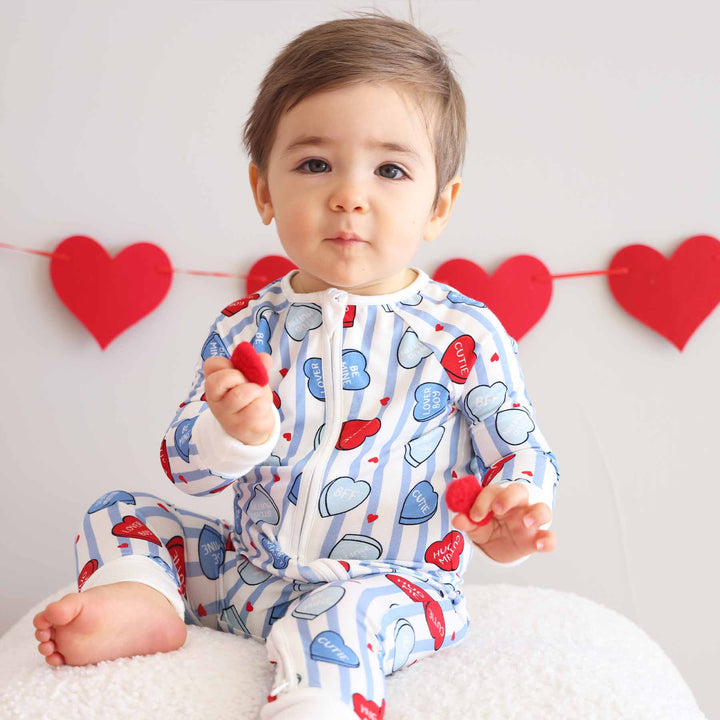 baby boy sitting on an ottoman in the sweet like candy blue convertible zip romper 