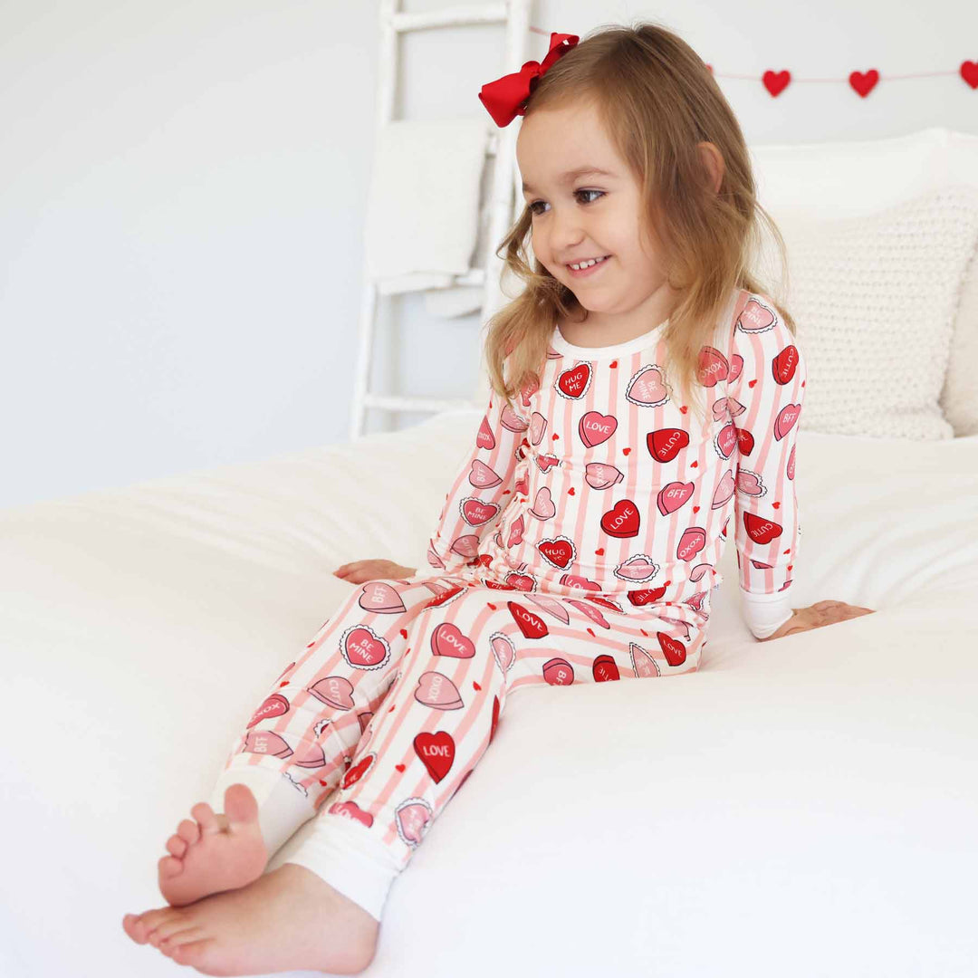 girl sitting on the bed in the sweet like candy pink bamboo viscose two piece pajama set 