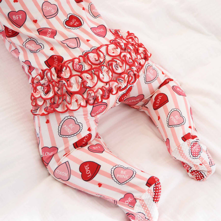 ruffle bottom valentine's day footie for babies with pink stripes and pink and red conversation heart candy