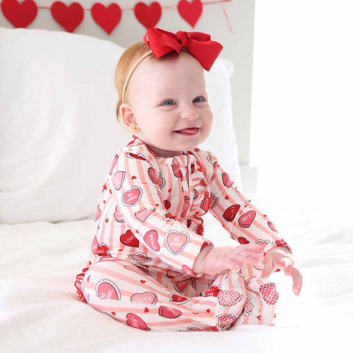sweet like candy pink stripe candy heart bamboo zipper footie for baby girls with a matching red ribbon bow headband 