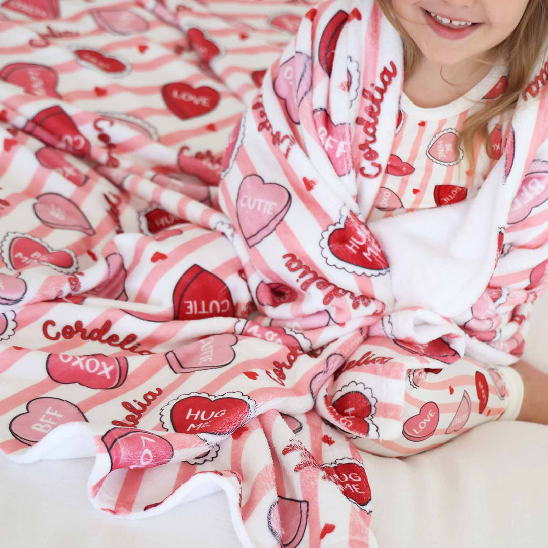 close up of sweet like candy personalized kids blanket in pink with matching two piece pajamas