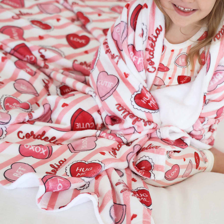 close up of sweet like candy personalized kids blanket in pink with matching two piece pajamas