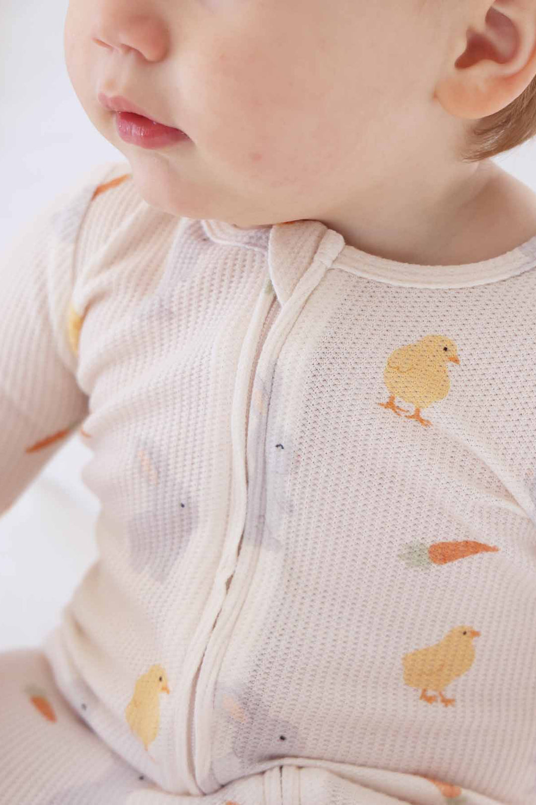 closeup of bamboo waffle zipper footie with chicks, carrots and bunnies 
