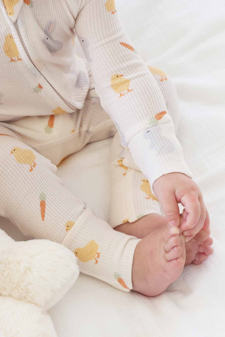 closeup of white easter bamboo waffle pajama romper with chicks, bunnies and carrots print 