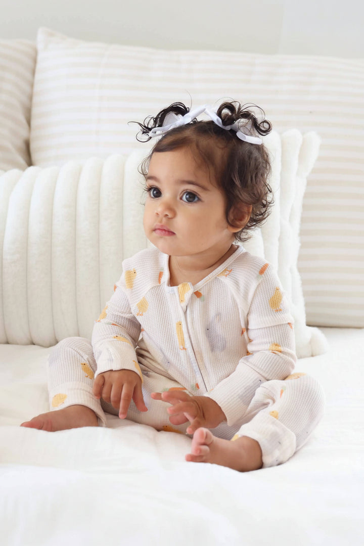 baby girl wearing easter bamboo waffle pajama romper with long sleeves and flip mitts and footies 
