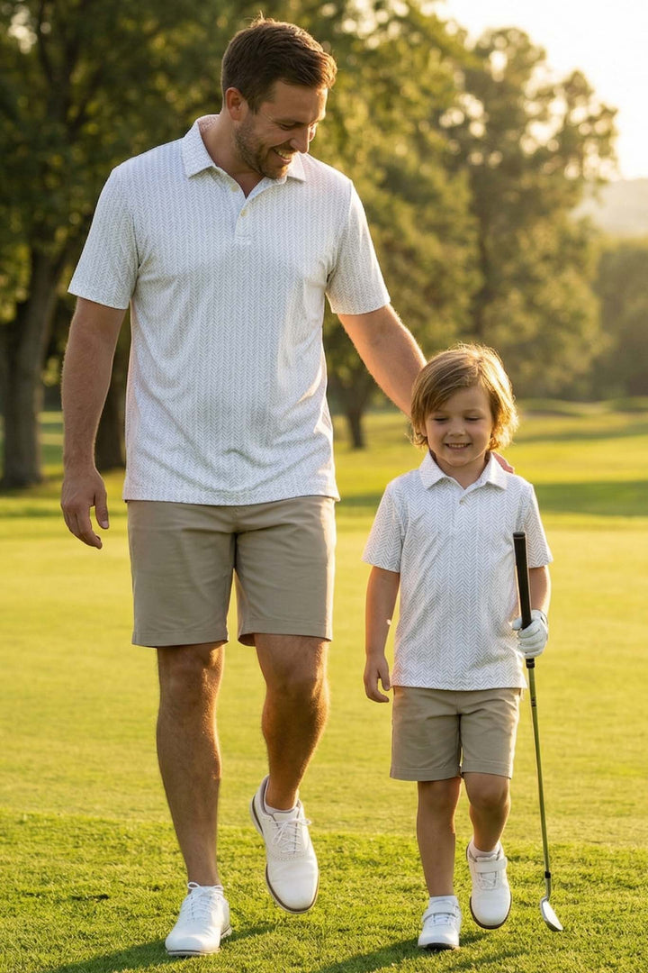 father and son walking on golf course in tee'd up white polo shirts 