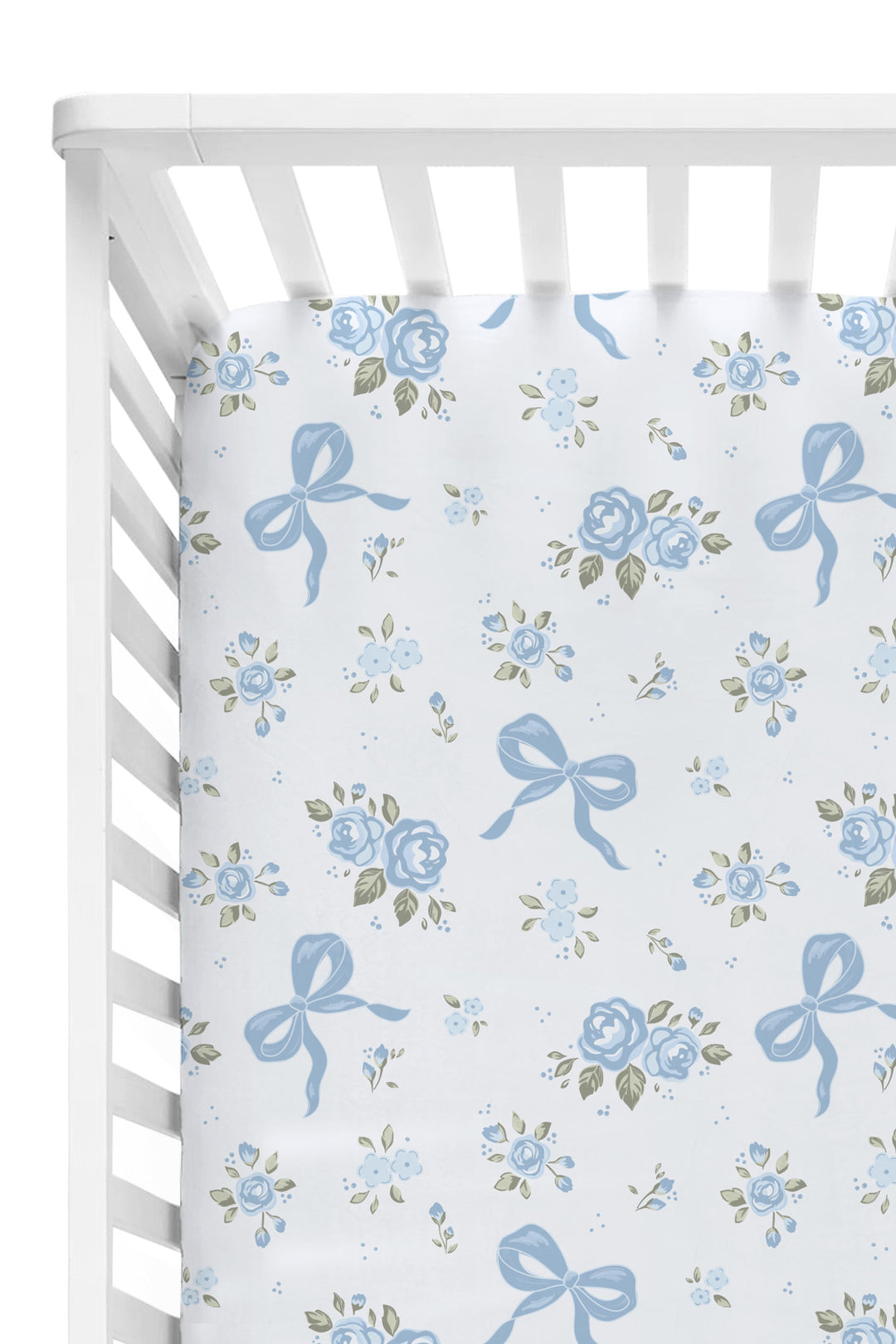 White crib fitted with a Tied In Blooms crib sheet in blue floral and bow print