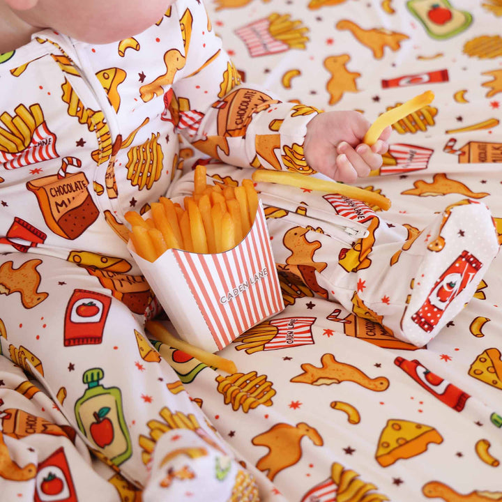 baby wearing a food themed footie with a french fry box with caden lane logo