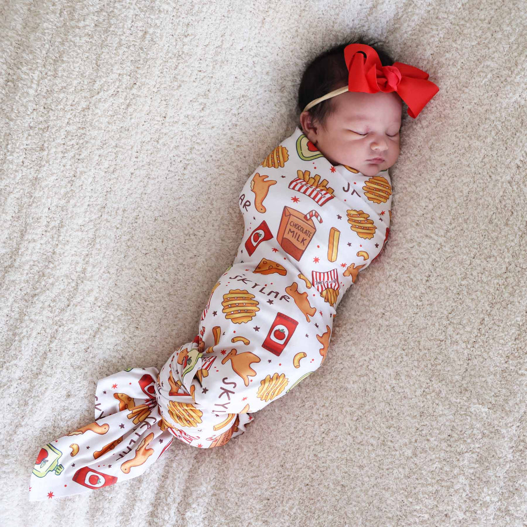 baby girl wrapped in a fast food themed personalized swaddle blanket 