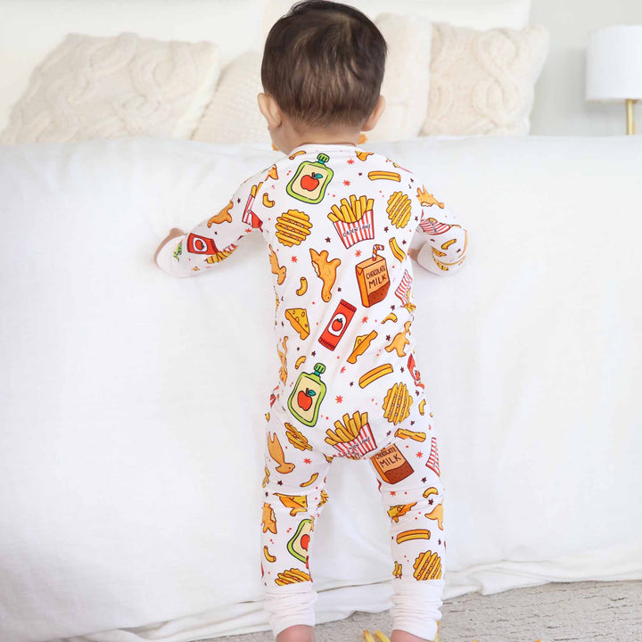 baby boy standing up wearing the tiny bites zip romper pajama 