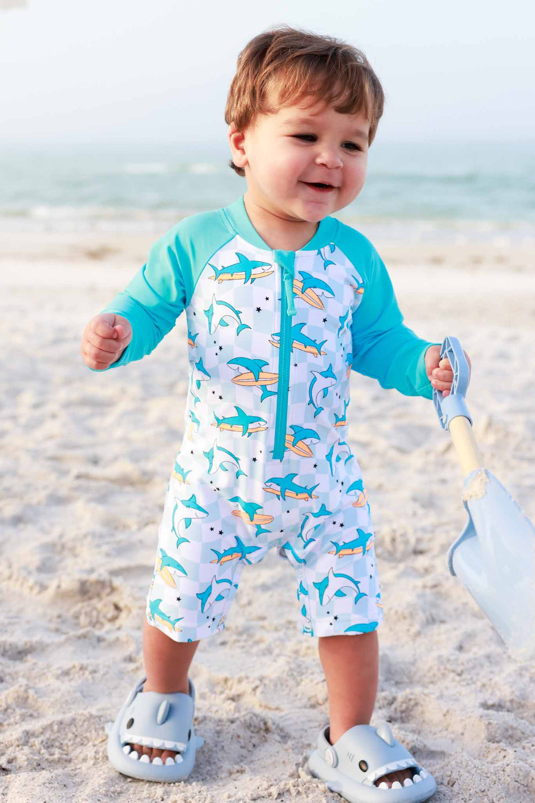 boy walking on beach in totally jawsome upf 50+ shortie romper 