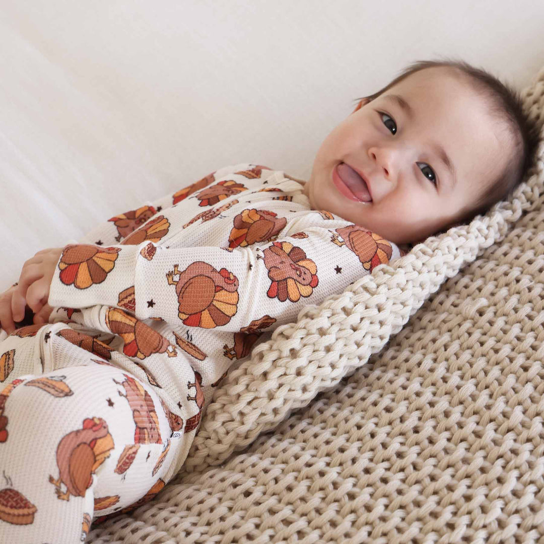 cream bamboo waffle convertible zip romper with brown turkeys with red, yellow and brown feathers with steaming pumpkin pies 