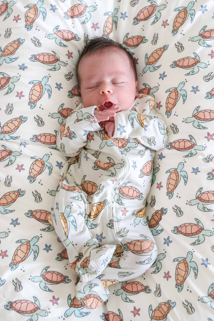 turtley rad bamboo swaddle blanket on a baby – gender neutral turtle print